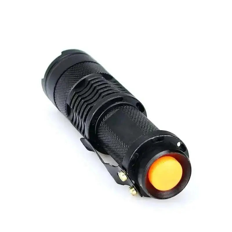 Mała czarna latarka LED 9,5 cm z metalowym klipsem i pomarańczowym włącznikiem, aluminiowa obudowa, teksturowana powierzchnia, idealna do EDC i turystyki