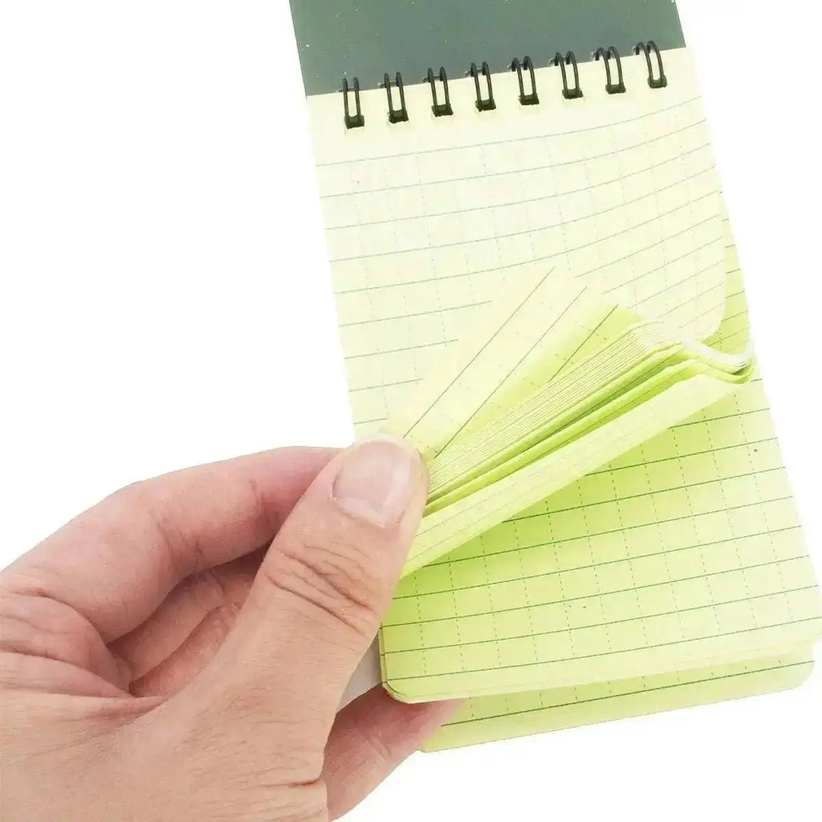 WarriorGear.eu All Weather camouflage spiral-bound notepad with yellow lined paper, held by a hand.