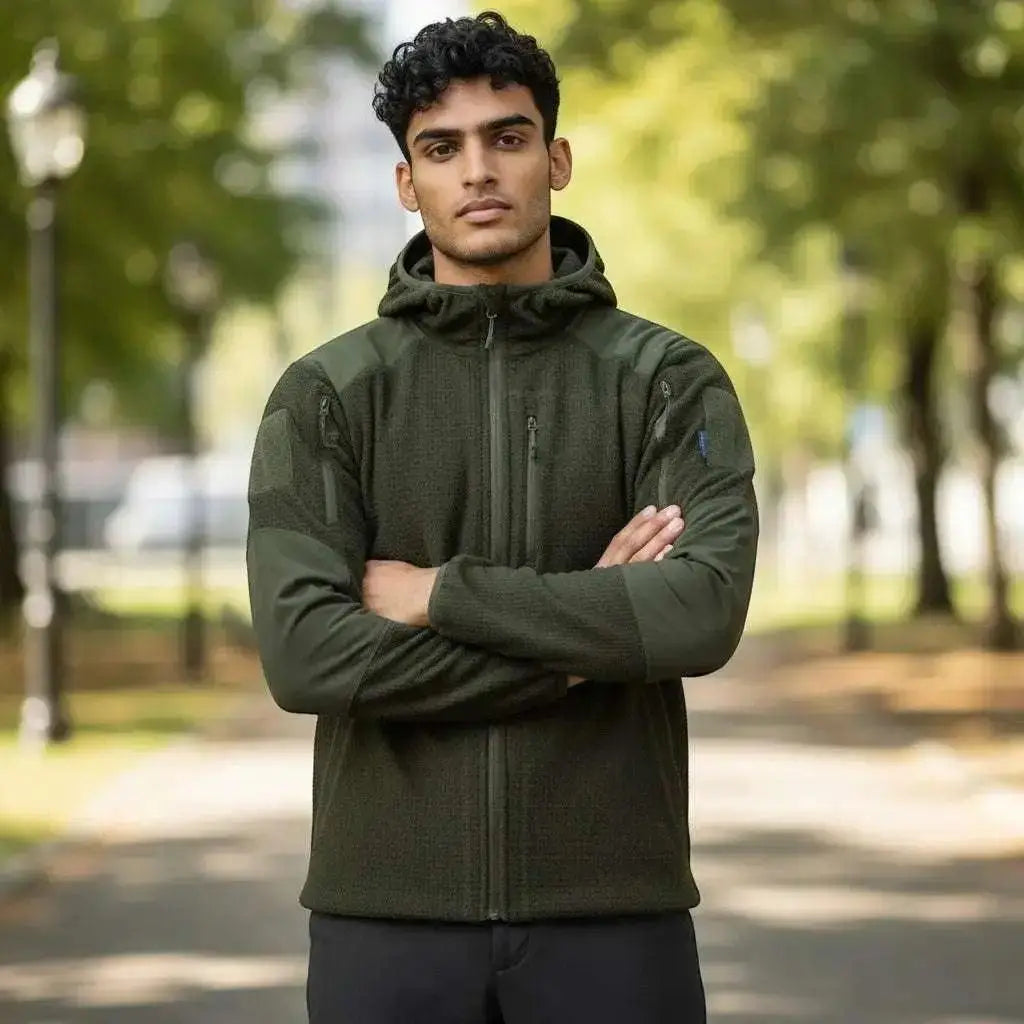 WarriorGear.eu olive green tactical fleece hoodie with reinforced shoulders and velcro patches. Model arms crossed.
