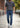 WarriorGear.eu men's blue stretch denim tactical jeans with reinforced knees and multiple pockets, worn by a model walking outdoors.